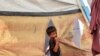 A boy stands outside a tent at a camp for people displaced by conflict in Khan Yunis in the southern Gaza Strip on July 11, 2024, amid the ongoing conflict in the Palestinian territory between Israel and Hamas.