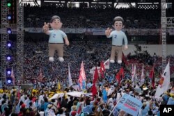 Balon 'gemoy' capres Prabowo Subianto (kiri) dan pasangannya Gibran Rakabuming Raka, putra sulung Presiden Indonesia Joko Widodo, dipajang saat kampanye di Stadion Utama Gelora Bung Karno di Jakarta, 10 Februari 2024. (AP/Achmad Ibrahim)