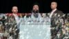 FILE - Hezbollah leader Sayyed Hassan Nasrallah, center, escorted by his bodyguard Yasser Nimr Qarnabsh, right, addresses supporters reflected in bulletproof glass in the southern suburbs of Beirut, Lebanon, Oct. 28, 2005. 