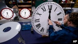 FILE - Ian Roders fastens the hands to a clock at Electric Time Company, Nov. 1, 2022, in Medfield, Massachusetts. President-elect Donald Trump has said he wants to eliminate daylight saving time.