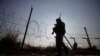 FILE - An Indian soldier patrols along the India-Pakistan international border in Kathua district, Dec. 6, 2013.