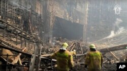 FILE - In this photo taken from video released by the Investigative Committee of Russia on March 23, 2024, firefighters work in the burned concert hall after an attack on the building of the Crocus City Hall in Moscow. The attack left 145 dead.