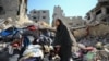 A Palestinian woman inspects the damage after Israeli forces withdrew from Shejaiya neighborhood following a ground operation, amid the Israel-Hamas conflict, in eastern part of Gaza City, July 10, 2024.