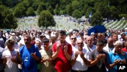 Bosnian Muslim men pray during the mass burial ceremony for 14 newly identified victims of the Srebrenica genocide, at the Srebrenica Memorial Centre, in Potocari, Bosnia, July 11, 2024.