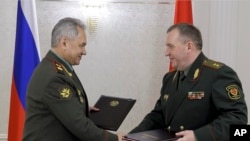 Ruski ministar odbrane Sergej Šojgu i beloruski ministar odbrane Viktor Krenin razmenjuju dokumente posle sastanka Saveta ministara odbrane Organizacije za kolektivni sporazum o bezbednosti (CSTO) u Minsku, Belorusija, 25. maj 2023. (Foto: AP / Vadim Savitski)