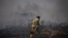 A firefighter works to extinguish a fire following an attack from Lebanese Hezbollah group in the Israeli-controlled Golan Heights, July 4, 2024. 