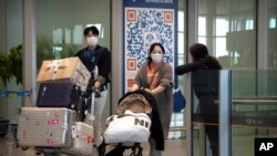 资料照片：2023年4月26日，乘坐国际航班抵达北京机场的旅客走出抵达区。（美联社照片）