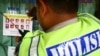 Seorang polisi menempelkan stiker daftar pencarian orang untuk tersangka teroris di sebuah kaca jendela di Malang, Jawa Timur, 30 September 2011. (Foto: Aman Rochman/AFP)