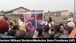 This photo supplied by MSF (Doctors Without Borders) shows health workers educating children in Goma, Congo, on the symptoms of mpox disease, May 31, 2023.
