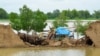 A flood victim retrieves usable items from his damaged house following rains and floods during the monsoon season in Jafarabad, Pakistan, Aug. 26, 2022. 