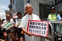 FILE - Cardinal Joseph Zen, center, and other religious protesters hold placards with 'Respects religious freedom' written on them during a demonstration outside the China Liaison Office in Hong Kong, July 11, 2012.