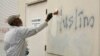 Čovek slika preko rasističkih grafita na zidu džamije u Rozvilu u Kaliforniji, 1. februar 2017. (Foto: AP/Rich Pedroncelli)
