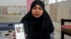 Kartika Puspitasari menunjukkan foto dirinya dengan bekas luka di lengan akibat cedera yang dialami majikan sebelumnya di Hong Kong, di Padang pada 10 Februari 2023. (Foto: AFP/M. Sulthan Azzam)