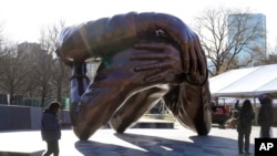 Prolaznici prolaze pored bronzane skulpture "Zagrljaj", spomenik Martinu Luteru Kingu mlađem i Koreti Skot King, Boston, 10. januar 2023. (Foto: AP/Steven Senne)