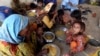 Victims of the unprecedented flooding from monsoon rains receive relief food organized by the Alkhidmat Foundation, in Jaffarabad, a district of Pakistan's southwestern Baluchistan province, Sept. 5, 2022. 
