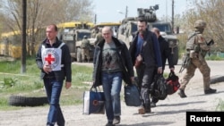 Civli u pratnji radnika Crvenog krsta koji su 1. maja uspešno evakuisani iz Azovstala