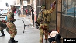 FILE: Amasotsha atshaya abantu abatshengisela emigwaqweni eZimbabwe, Harare, Zimbabwe, Aug. 1, 2018.