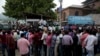 Indian migrant workers wait outside the government transport yard waiting to buy bus tickets to leave the region, during curfew in Srinagar, Indian controlled Kashmir, Aug. 7, 2019.