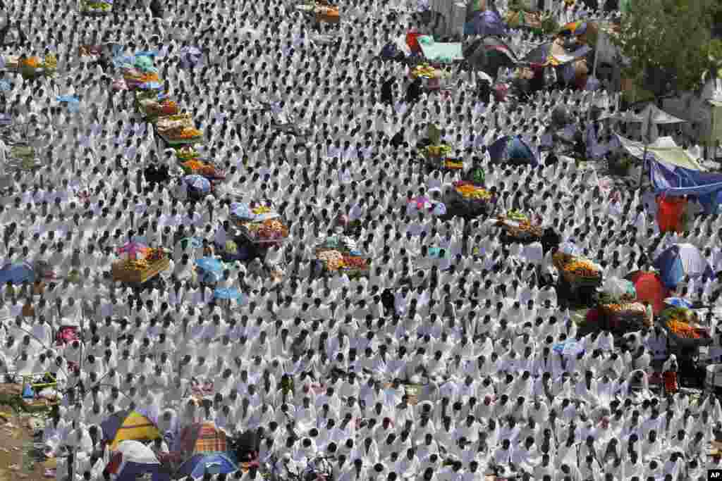 Muslim pilgrims pray the noon prayers near fruit carts in Arafat, near the holy city of Mecca, Saudi Arabia, Oct. 14, 2013.