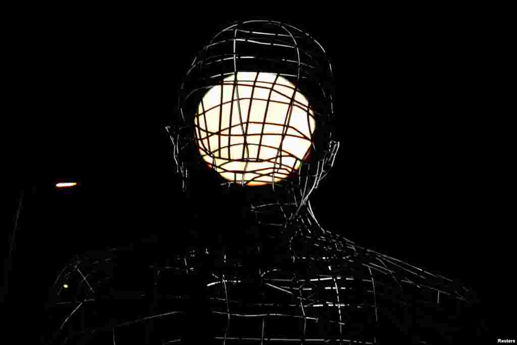 The supermoon rises behind "El Pensador" (The Thinker) in Dos Hermanas, near Seville, southern Spain, Nov. 14, 2016.