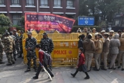 Schoolchildren walk past police outside the Uttar Pradesh Bhawan (state house) during a demonstration against the crackdown on protesters in Uttar Pradesh state, over India's new citizenship law, in New Delhi, Dec. 26, 2019.