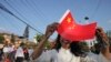 A woman holds a Chinese flag and stands by the side of a road to welcome Chinese President Xi Jinping in Kathmandu, Nepal, Oct. 12, 2019. 