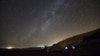 FILE - A meteor streaks across the sky in the early morning as people watching during the Perseid meteor shower in Ramon Carter near the town of Mitzpe Ramon, southern Israel, August 13, 2015. The Perseid meteor shower is sparked every August when the Earth passes through a stream of space debris left by comet Swift-Tuttle.