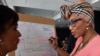 Anne Aly (L), the first Muslim woman elected to Australia's federal parliament, has spoken of how racism and domestic violence has shaped her career. 