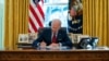 FILE - President Joe Biden signs a series of executive orders on health care, in the Oval Office of the White House, Jan. 28, 2021.