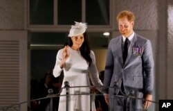 Britain's Prince Harry and Meghan, Duchess of Sussex wave from the balcony of the Grand Pacific Hotel in Suva, Fiji, Oct. 23, 2018.