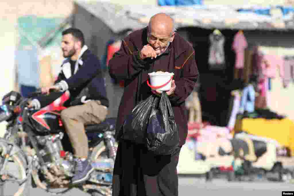 A man eats food in a rebel-held besieged area in Aleppo, Syria.