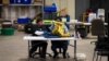 Elections workers at the Fulton County Georgia elections warehouse check in voting machine memory cards that store ballots following the Senate runoff election in Atlanta, Jan. 5, 2021.