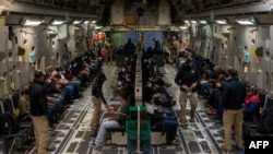 This image released by the Department of Defense shows undocumented migrants awaiting takeoff for a removal flight at the Tucson International Airport, Arizona, Jan. 23, 2025. (AFP photo / DVIDS / Department of Defense / Senior Airman Devlin Bishop) 