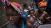 Displaced women with their children wait for assistance at a building used by refugees as shelter in Pemba, Mozambique, after they fled attacks in Palma in northern Mozambique, April 19, 2021.