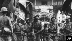 FILE - Japanese soldiers, their rifles shouldered, are seen as they march into the city and port of Ningbo, in southeastern China, May 14, 1941.