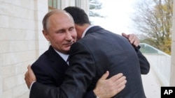 Presiden Rusia Vladimir Putin (kiri), memeluk Presiden Suriah Bashar Assad di kediaman Bocharov Ruchei di resor Laut Hitam Sochi, Rusia pada 2027. (Mikhail Klimentyev, Kremlin Pool Photo via AP)