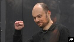 FILE - Russian opposition activist Vladimir Kara-Murza gestures while standing in a defendants' cage at the Moscow City Court in Moscow, Russia, on July 31, 2023.