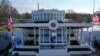 FILE - Pekerja melanjutkan sentuhan akhir pada mimbar peninjauan presiden di Pennsylvania Avenue di luar Gedung Putih, Washington, 16 Januari 2025, menjelang pelantikan Presiden terpilih Donald Trump.