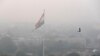 A bird flies past as New Delhi's skyline is seen enveloped in smog and dust, in New Delhi, India, Nov. 1, 2019.