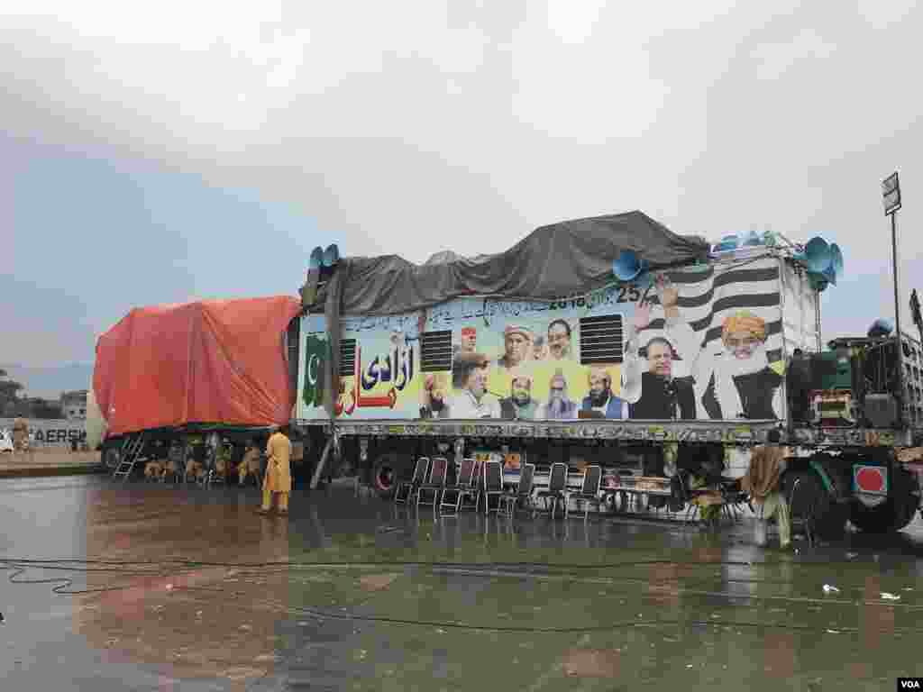 بارش سے بچنے کے لیے آزادی مارچ کے کچھ شرکا نے اس کنٹینر کے نیچے عارضی قیام کیا جس پر مارچ کے رہنما شرکا سے خطاب کرتے ہیں۔ کنٹینر کا اوپری حصہ ترپال سے ڈھکا ہوا ہے جب کہ لاؤڈ اسپیکر اب بھی نمایاں ہیں۔ 