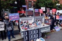 FILE - Families of COVID-19 victims who passed away in New York nursing homes protest Gov. Andrew Cuomo's response to coronavirus cases in care centers, in the Brooklyn borough of New York, Oct. 18, 2020.