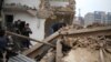 FILE - A woman reacts after trying to protect her home as demolition workers move in, in Yangji village, Guangzhou, China, March 21, 2012. Yangji was scheduled for redevelopment and gradually demolished, making way for modern housing.