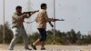 FILE - Fighters fire at Islamic State militants near Sirte on March 15, 2015. 