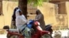 Women chat while sitting on their bikes in a district of Maroua, Cameroon, Nov. 20, 2013. 