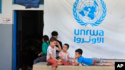 FILE - Anak-anak Palestina yang melarikan diri bersama orang tua mereka dari rumah mereka di kamp pengungsi Palestina Ein el-Hilweh, berkumpul di halaman belakang sekolah UNRWA, di Sidon, Lebanon, 12 September 2023. (Mohammed Zaatari/AP)