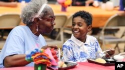 FILE - Third grader Dallin Curry, 8, talks with his grandmother Mary Durr on Sept. 6, 2024, during a Grandparents Day celebration in the lunchroom at Burns Elementary School in Owensboro, Ky. 