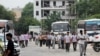 Laborers walk along a street next to a Maruti Suzuki India Ltd. manufacturing plant in Manesar in the northern state of Haryana, India, Aug. 2, 2019.