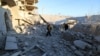 Residents inspect damage after airstrikes by pro-Syrian government forces in Anadan city, about 10 kilometers away from the towns of Nubul and Zahraa, Northern Aleppo countryside, Feb. 3, 2016.