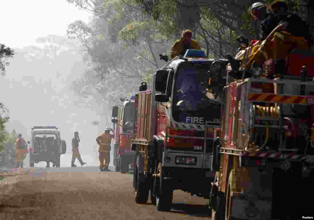 Rural Fire Service frefighters take a break after trying to extinguish a fire approaching homes near the Blue Mountains suburb of Faulconbridge, west of Sydney, Oct. 24, 2013.