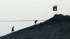 FILE - Militants with the Islamic State group are seen after placing their group's flag on a hilltop at the eastern side of the town of Kobani, Syria. 